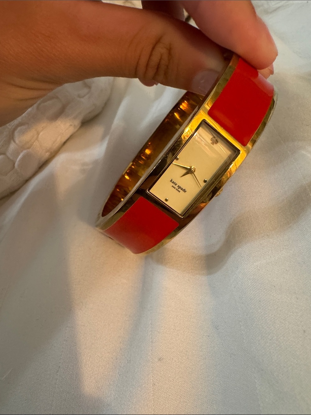 kate spade gold-tone bangle watch with red enamel panels